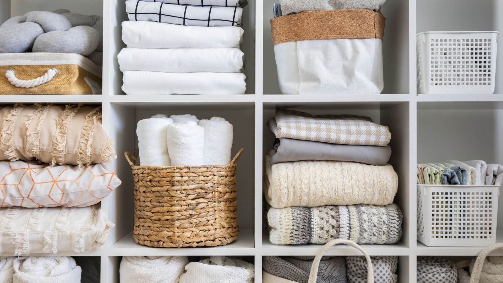 Organized linen closet with neatly folded towels and linens
